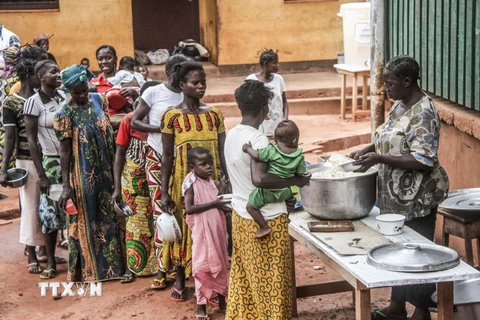 Cha mẹ và các bệnh nhi xếp hàng nhận thức ăn tại bệnh viện Berberati, Cộng hòa Trung Phi. (Nguồn: AFP/TTXVN)