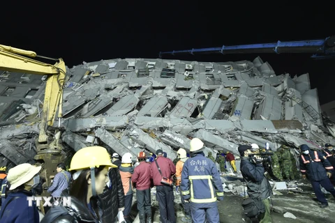 Nhân viên cứu hộ nỗ lực tìm kiếm nạn nhân bị chôn vùi trong những đống đổ nát sau vụ sập toà chung cư 17 tầng do động đất tại thành phố Đài Nam ngày 6/2. (Nguồn: AFP/TTXVN)