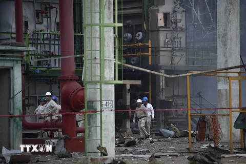 Các công nhân tìm kiếm nạn nhân mất tích trong vụ nổ tại nhà máy hóa dầu Pajaritos. (Nguồn: AFP/TTXVN)