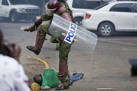 Cảnh sát chống bạo động đánh người. (Nguồn: AP)