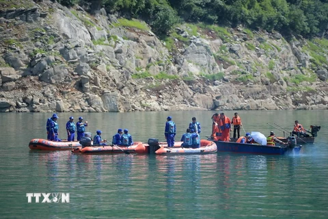 Nhân viên cứu hộ tìm kiếm người mất tích sau vụ lật tàu ngày 5/6. (Nguồn: THX/TTXVN)