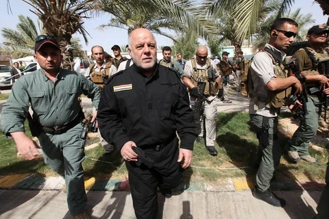 Thủ tướng Haider al-Abadi (áo đen) đến thăm một căn cứ quân sự. (Nguồn: Reuters)