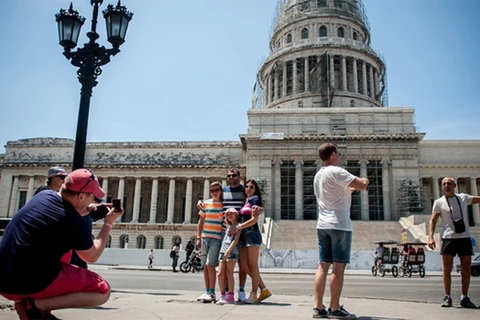Du khách nước ngoài chụp ảnh tại La Havana. (Nguồn: AFP)