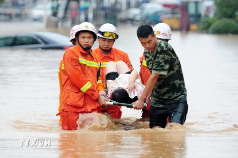 Nhân viên cứu hộ sơ tán người dân khỏi các khu vực ngập lụt ở Jiujiang, tỉnh Giang Tây, ngày 15/6. (Nguồn: EPA/TTXVN)