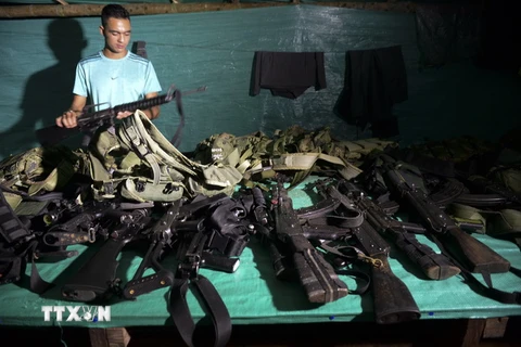 Một thành viên của FARC kiểm tra vũ khí tại một doanh trại ở Vegaez, Khu hành chính Antioquia, Colombia ngày 1/1, trước khi giao nộp chính quyền. (Nguồn: AFP/TTXVN)