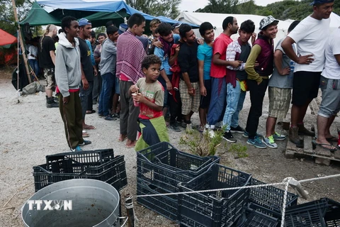 Người di cư xếp hàng chờ nhận khẩu phần ăn. Ảnh minh họa. (Nguồn: AFP/TTXVN)