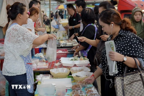 Người dân mua đồ ăn tại một con phố ở Bangkok, Thái Lan. (Nguồn: AFP/TTXVN)