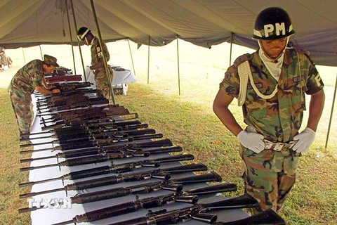 Thành viên lực lượng cảnh sát vũ trang Colombia bên số vũ khí thu giữ được của các tay súng FARC tại Cali ngày 14/5/2002. (Nguồn: AFP/TTXVN)