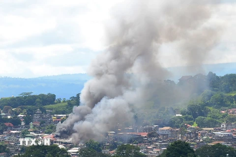 Khói bốc lên từ một tòa bốc cháy ở Marawi sau khi máy bay quân đội tấn công mục tiêu của phiến quân Hồi giáo ngày 18/6. (Nguồn: AFP/TTXVN)