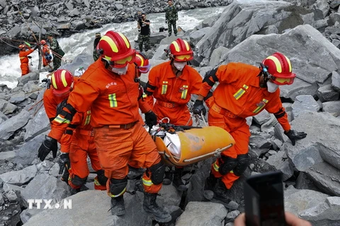 Lực lượng cứu hộ chuyển thi thể nạn nhân tại hiện trường vụ sạt lở núi lần thứ nhất tại huyện Mậu, tỉnh Tứ Xuyên ngày 25/6. (Nguồn: AFP/TTXVN)