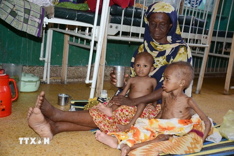 Một bà mẹ chăm sóc hai con bị suy dinh dưỡng điều trị tại bệnh viện ở thủ đô Mogadishu, Somalia. (Nguồn: AFP/TTXVN)