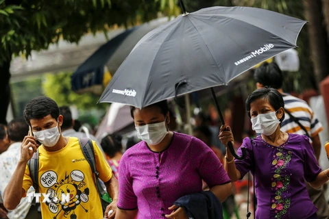 Người dân đeo khẩu trang đề phòng lây nhiễm virus H1N1 tại Yangon, Myanmar ngày 24/7. (Nguồn: EPA/TTXVN)