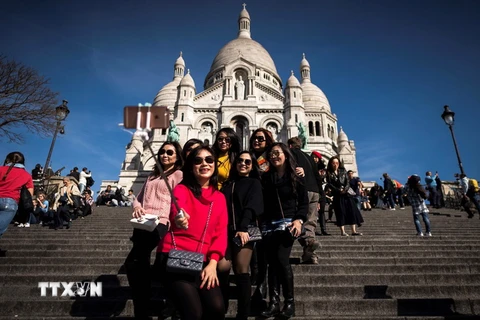  Khách du lịch tham quan thủ đô Paris, Pháp ngày 30/3. (Nguồn: AFP/TTXVN)