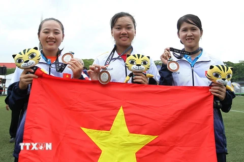 Đội tuyển bắn cung Việt Nam vui mừng với chiếc huy chương bạc.(Ảnh: Quốc Khánh/TTXVN)