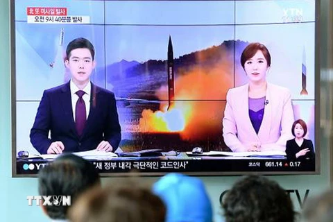Người dân theo dõi bản tin về vụ phóng tên lửa của Triều Tiên trên một màn hình ti vi tại một nhà ga ở Seoul, Hàn Quốc ngày 4/7. (Nguồn: Kyodo/TTXVN)