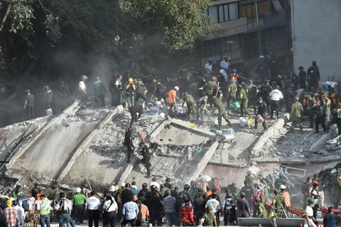 Lực lượng cứu hộ tìm kiếm người mất tích sau trận động đất ở Mexico City ngày 19/9. (Nguồn: AFP/TTXVN)