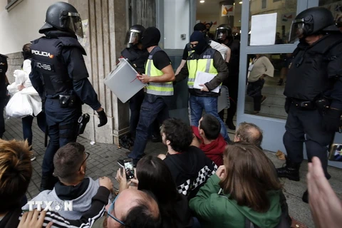 Cảnh sát Tây Ban nha tịch thu các hòm phiếu tại một điểm bỏ phiếu ở Barcelona ngày 1/10. (Nguồn: AFP/TTXVN)
