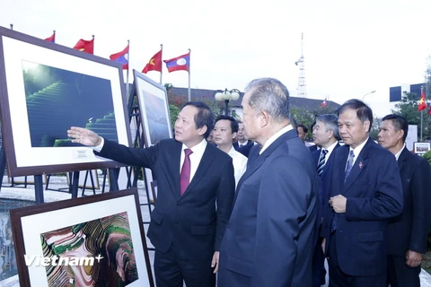 Bộ trưởng Trương Minh Tuấn cùng các quan khách đang thăm quan Triển lãm. (Ảnh: Phạm Kiên/Vietnam+)