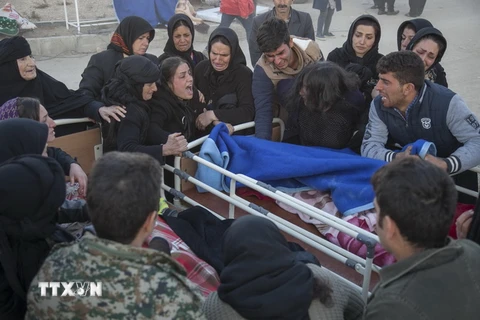 Người dân khóc than bên thi thể nạn nhân trong trận động đất ở Kermanshah, Iran ngày 13/11. (Nguồn: AFP/TTXVN)