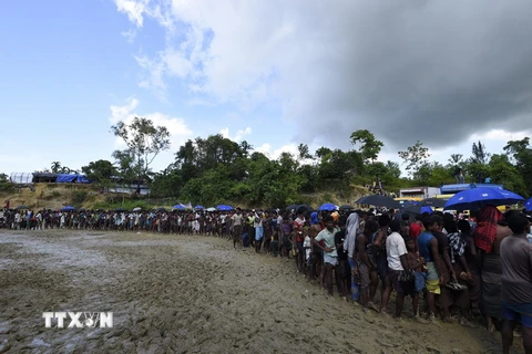 Người tị nạn Rohingya xếp hàng nhận thực phẩm cứu trợ tại trại tị nạn Balukhali gần Gumdhum, Bangladesh ngày 25/9. (Nguồn: AFP/TTXVN)
