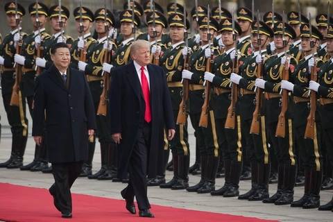 Chủ tịch Trung Quốc Tập Cận Bình (trái) và Tổng thống Mỹ Donald Trump (giữa) duyệt đội danh dự tại lễ đón ở Bắc Kinh ngày 9/11. (Nguồn: AFP/TTXVN)