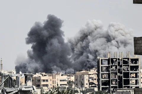 Khói bốc lên sau một cuộc không kích ở Raqqa, Syria. /(Nguồn: AFP/TTXVN)