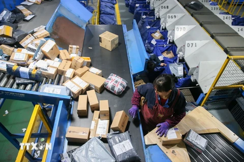 Nhân viên của Alibaba đóng gói hàng hóa trong ngày mua sắm khuyến mại trực tuyến tại Thượng Hải. (Nguồn: THX/TTXVN)