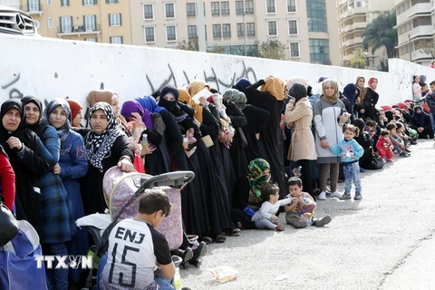 Người tị nạn Syria xếp hàng nhận đồ viện trợ. (Nguồn: AFP/TTXVN)