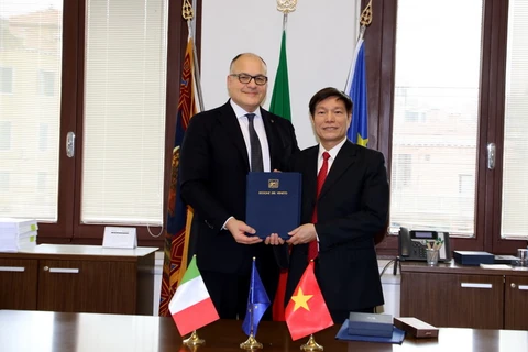 Quan chức phụ trách đối ngoại vùng Veneto, ông Diego Vecchiato trao MoU cho Tham tán Thương mại Việt Nam tại Italy Nguyễn Đức Thanh. (Ảnh: Ngự Bình/Vietnam+)
