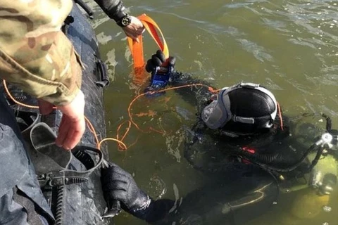 Thợ lặn đưa quả bom từ đáy sống lên bờ. (Nguồn: bbc.com)