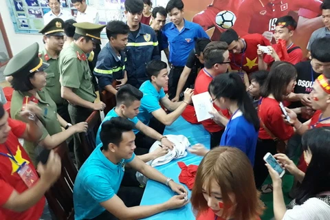 Các cầu thủ U23 Việt Nam ký tặng người hâm mộ tỉnh Ninh Thuận. (Ảnh: Nguyễn Thành/TTXVN)