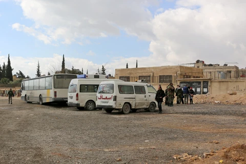 Binh sỹ quân đội Syria gác tại trạm kiểm soát Wafideen, khu vực lân cận Đông Ghouta, nơi thường dân và các tay súng đối lập được phép lên xe buýt và xe cứu thương rời khỏi Ghouta ngày 27/2. (Nguồn: AFP/TTXVN)