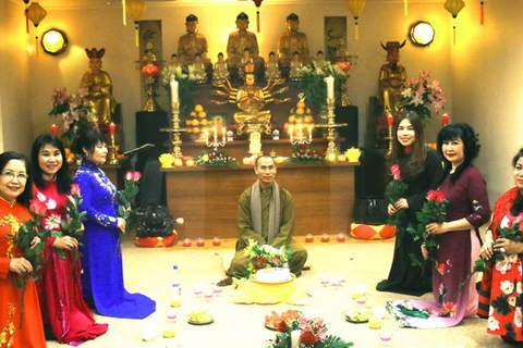 Sư thầy Thích Thiện Trí tặng hoa cho các tín nữ chủ chốt của Hội Phật tử. (Ảnh: Tâm Vinh/Vietnam+)