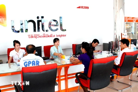 Khách hàng ký kết hợp đồng tại Unitel, Lào. (Ảnh: Hoàng Chương/TTXVN)