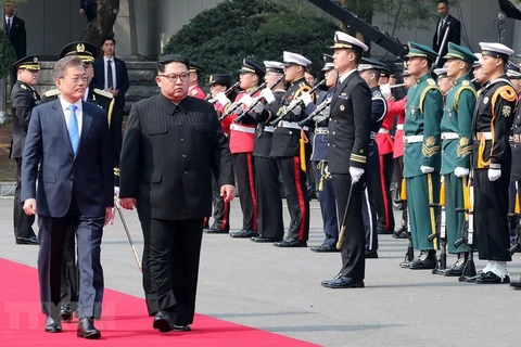 ổng thống Hàn Quốc Moon Jae-in và Nhà lãnh đạo Triều Tiên Kim Jong-un duyệt đội danh dự tại quảng trường ở làng đình chiến Panmunjom ngày 27/4. (Nguồn: YONHAP/TTXVN)