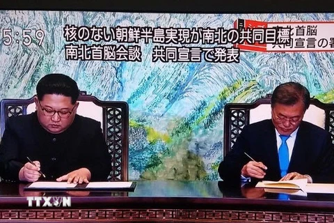Nhà lãnh đạo Triều Tiên Kim Jong-un (trái) và Tổng thống Hàn Quốc Moon Jae-in ký tuyên bố chung tại Hội nghị thượng đỉnh liên Triều ở làng đình chiến Panmunjom ngày 27/4. (Nguồn: YONHAP/TTXVN)