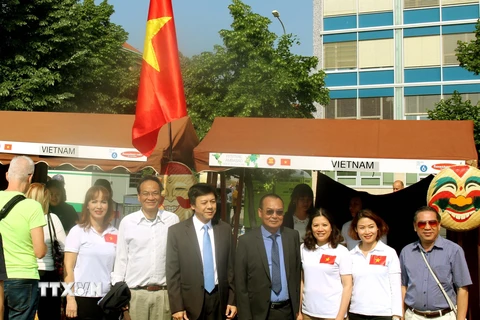 Đại sứ Việt Nam tại Sec Hồ Minh Tuấn (sơmi trắng, càvạt xanh) và các cán bộ Đại sứ quán tại quầy ẩm thực Việt Nam. (Ảnh: Trần Quang Vinh/TTXVN)
