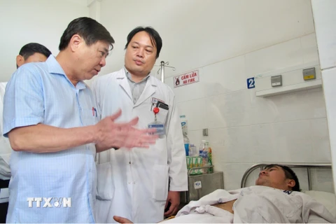 Chủ tịch Ủy ban nhân dân Thành phố Hồ Chí Minh Nguyễn Thành Phong thăm ''hiệp sỹ'' Nguyễn Đức Huy tại Bệnh viện Thống Nhất. (Ảnh: Đinh Hằng/TTXVN)