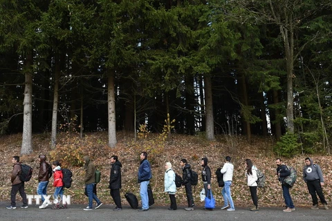 Người tị nạn chờ xe buýt sau khi vượt qua khu vực biên giới giữa Áo và Đức ở Wegscheid, miền nam Đức. (Nguồn: AFP/TTXVN)