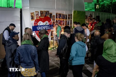 Người dân tập trung gần tòa Grenfell Tower ngày 14/6 để tưởng các nạn nhân xấu số trong vụ cháy tòa chung cư một năm trước. (Nguồn: AFP/TTXVN)