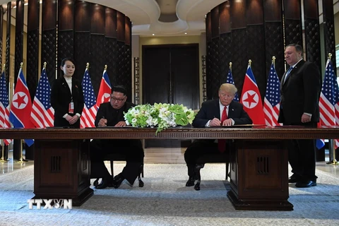 Tổng thống Mỹ Donald Trump (thứ 2, phải) và nhà lãnh đạo Triều Tiên Kim Jong-un (thứ 2, trái) ký tuyên bố chung tại hội nghị. (Nguồn: AFP/TTXVN)