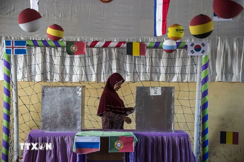 Cử tri bỏ phiếu trong cuộc bầu cử địa phương tại một điểm bầu cử ở Surabaya, Tây Java, Indonesia ngày 27/6. (Nguồn: Ảnh: AFP/TTXVN)