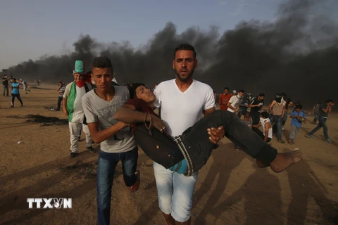 Chuyển người biểu tình Palestine bị thương trong cuộc xung đột với binh sỹ Israel tại khu vực biên giới Dải Gaza-Israel ngày 25/5. (Nguồn: THX/TTXVN)