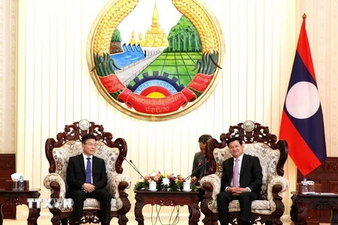 Thủ tướng Thongloun Sisoulith tiếp Bộ trưởng Lê Thành Long. (Ảnh: Phạm Kiên/TTXVN)