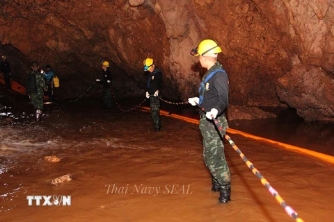 Lực lượng cứu hộ chuyển thiết bị vào hang Tham Luang để giải cứu đội bóng thiếu niên ngày 6/7. (Nguồn: EPA-EFE/TTXVN)