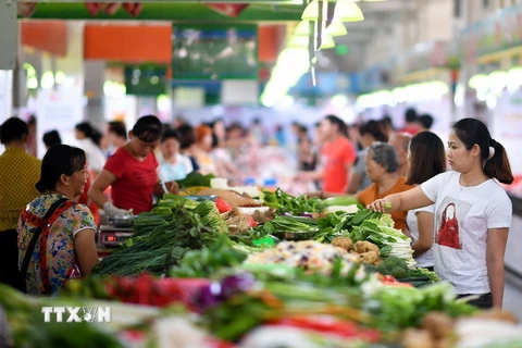 Người dân mua sắm tại một khu chợ ở Hải Nam, Trung Quốc. (Ảnh: AFP/TTXVN)
