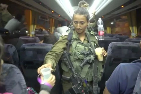 Một binh sỹ Israel đưa nước cho thành viên tổ chức Mũ bảo hiểm Trắng. (Nguồn: Reuters)