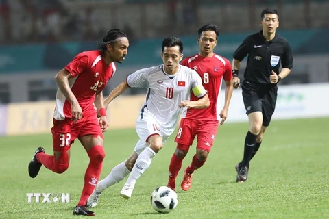 Pha tranh bóng của cầu thủ Olympic Việt Nam (áo trắng) và Olympic Nepal. (Ảnh: Hoàng Linh/TTXVN)