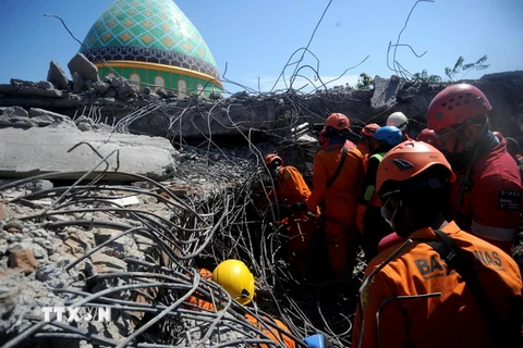 Lực lượng cứu hộ làm nhiệm vụ tại hiện trường đổ nát sau động đất tại Bắc Lombok, Indonesia ngày 8/8. (Ảnh: THX/TTXVN)