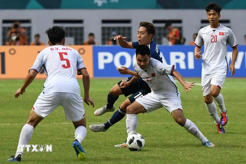 Pha tranh bóng quyết liệt giữa cầu thủ Phạm Đức Huy (thứ 2, phải) của Olympic Việt Nam và Kouta Wanabe (giữa, phía sau) của Olympic Nhật Bản trong trận đấu ở bảng D, ASIAD 2018 ở Cikarang, Indonesia ngày 19/8. (Ảnh: AFP/TTXVN)